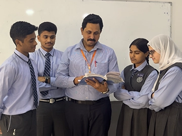 Indian high school Kuwait teacher explaining lesson to attentive students